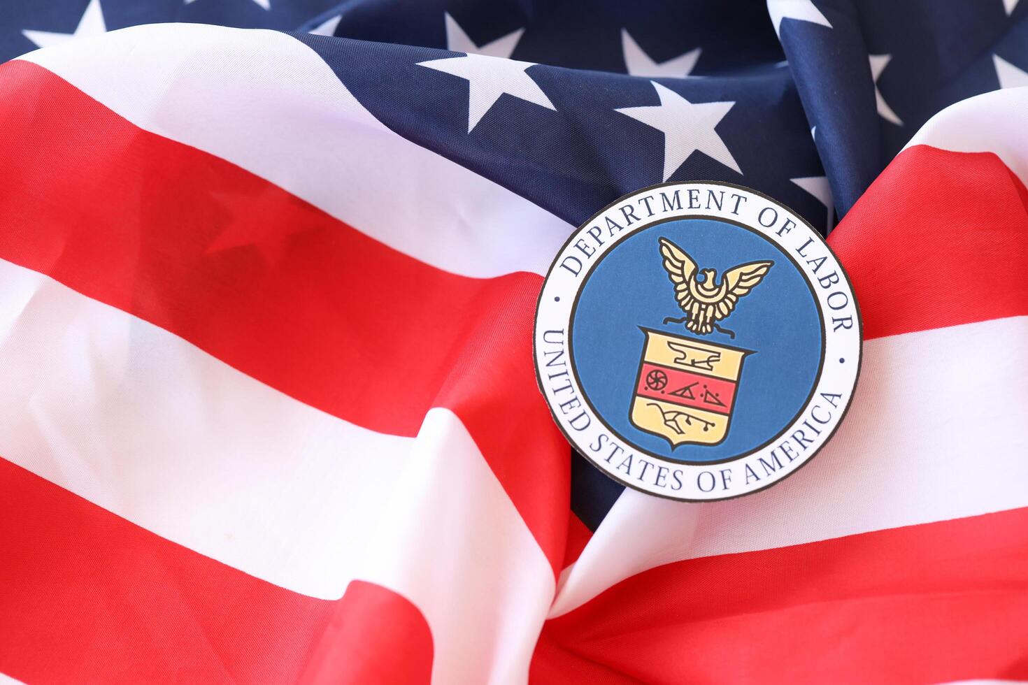 KYIV, UKRAINE - MARCH 9, 2024 US Department of Labor seal on United States of America flag photo