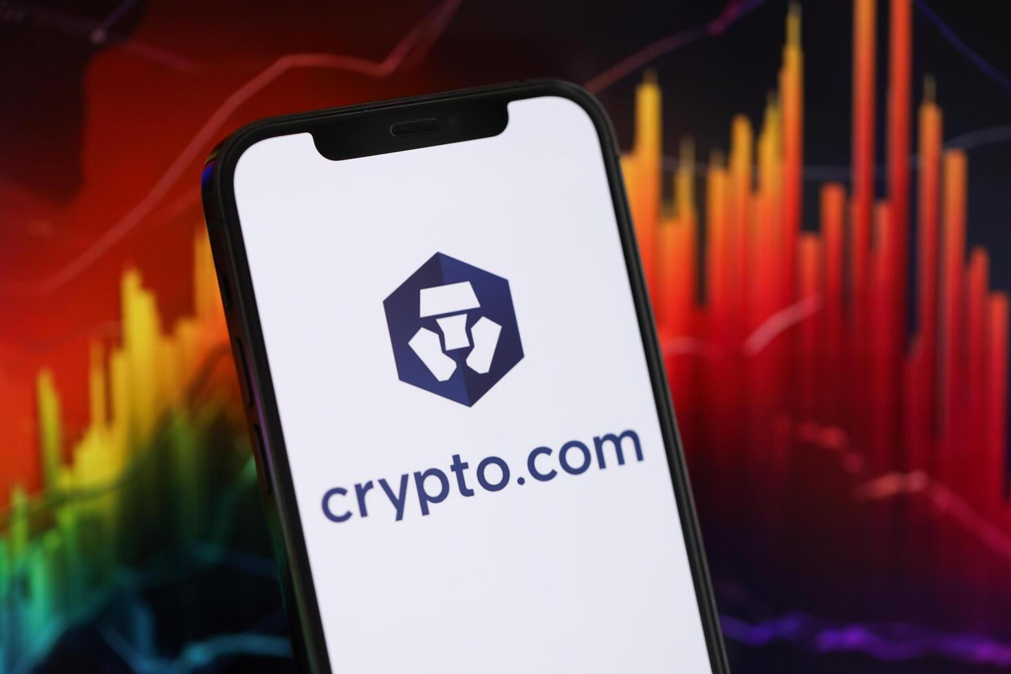KYIV, UKRAINE - MARCH 15, 2024 Crypto com logo on iPhone display screen and crypto currency value charts photo
