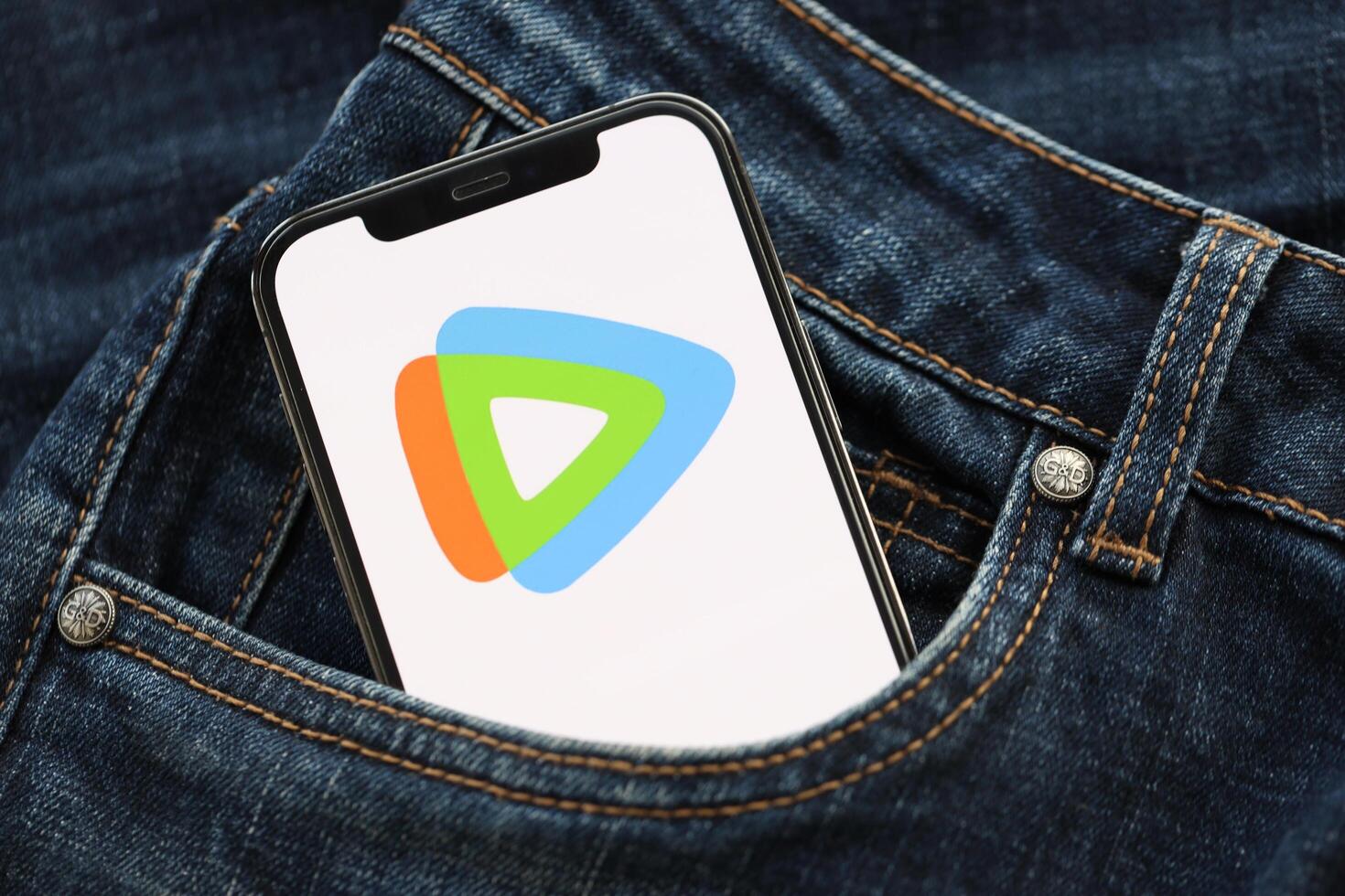 KYIV, UKRAINE - APRIL 1, 2024 Tencent WeTV icon on smartphone display screen in jeans pocket photo