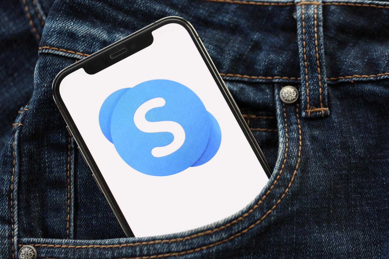 KYIV, UKRAINE - APRIL 1, 2024 Skype icon on smartphone display screen in jeans pocket photo