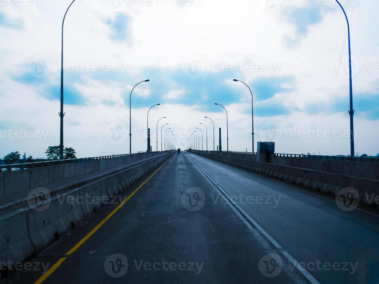 A bridge drawn with yellow and white color lines. There are lampposts on both sides of the bridge. photo