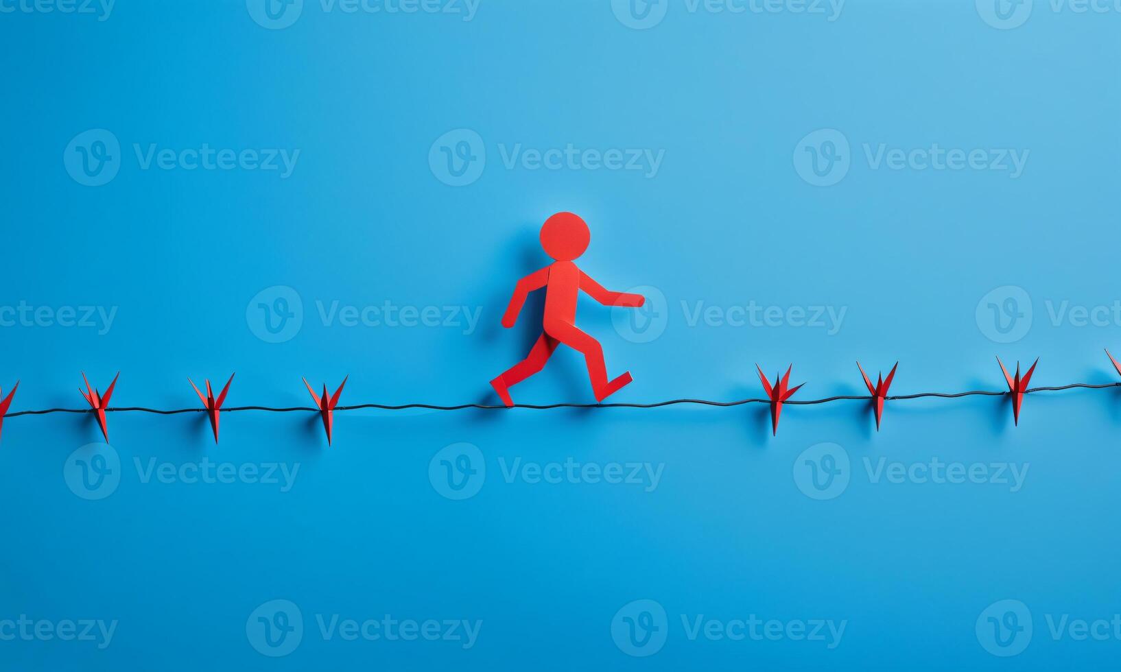A red paper cut person walking on wire with thorns, fighting, overcoming obstacles, isolated on blue background photo