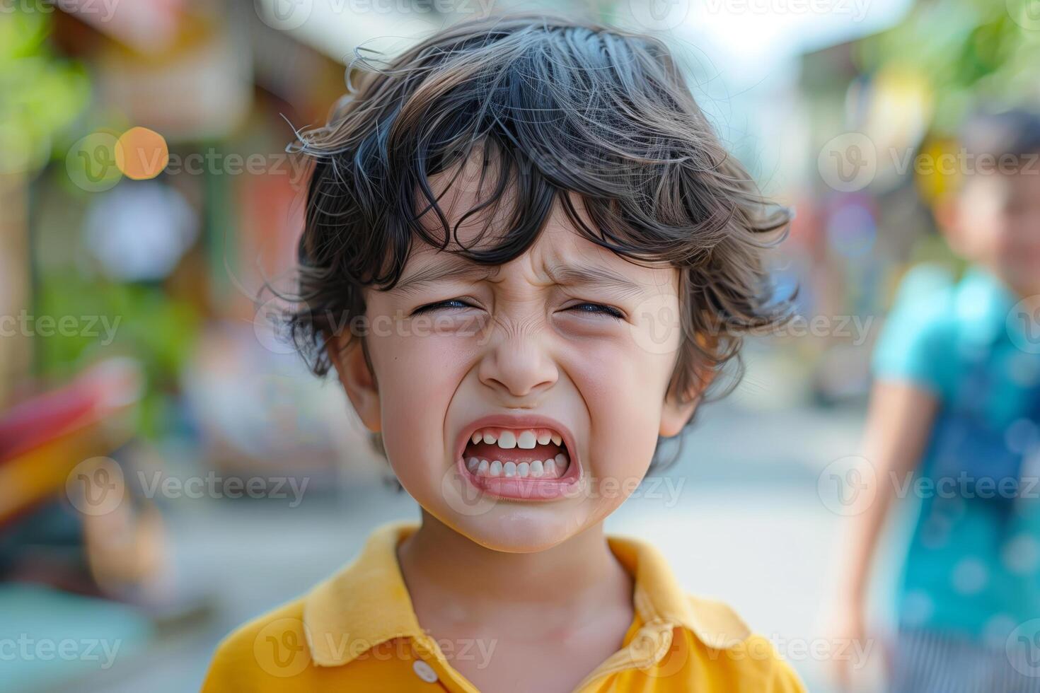 Young boy with angry expression outside on sunny day photo