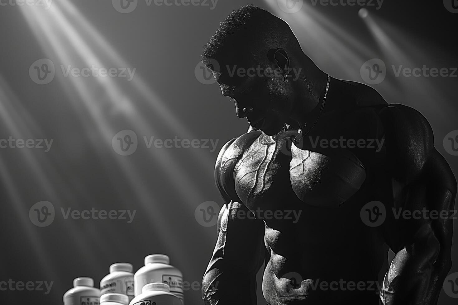 Muscular man posing under stage lights with protein supplements photo