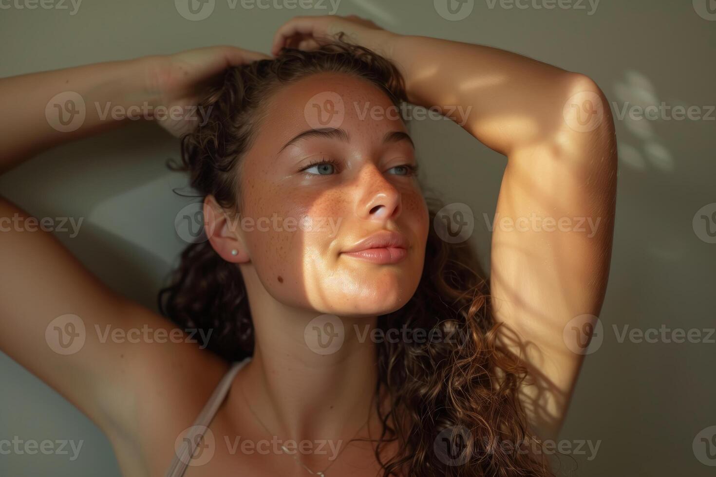 Young woman with curly hair posing in natural light photo
