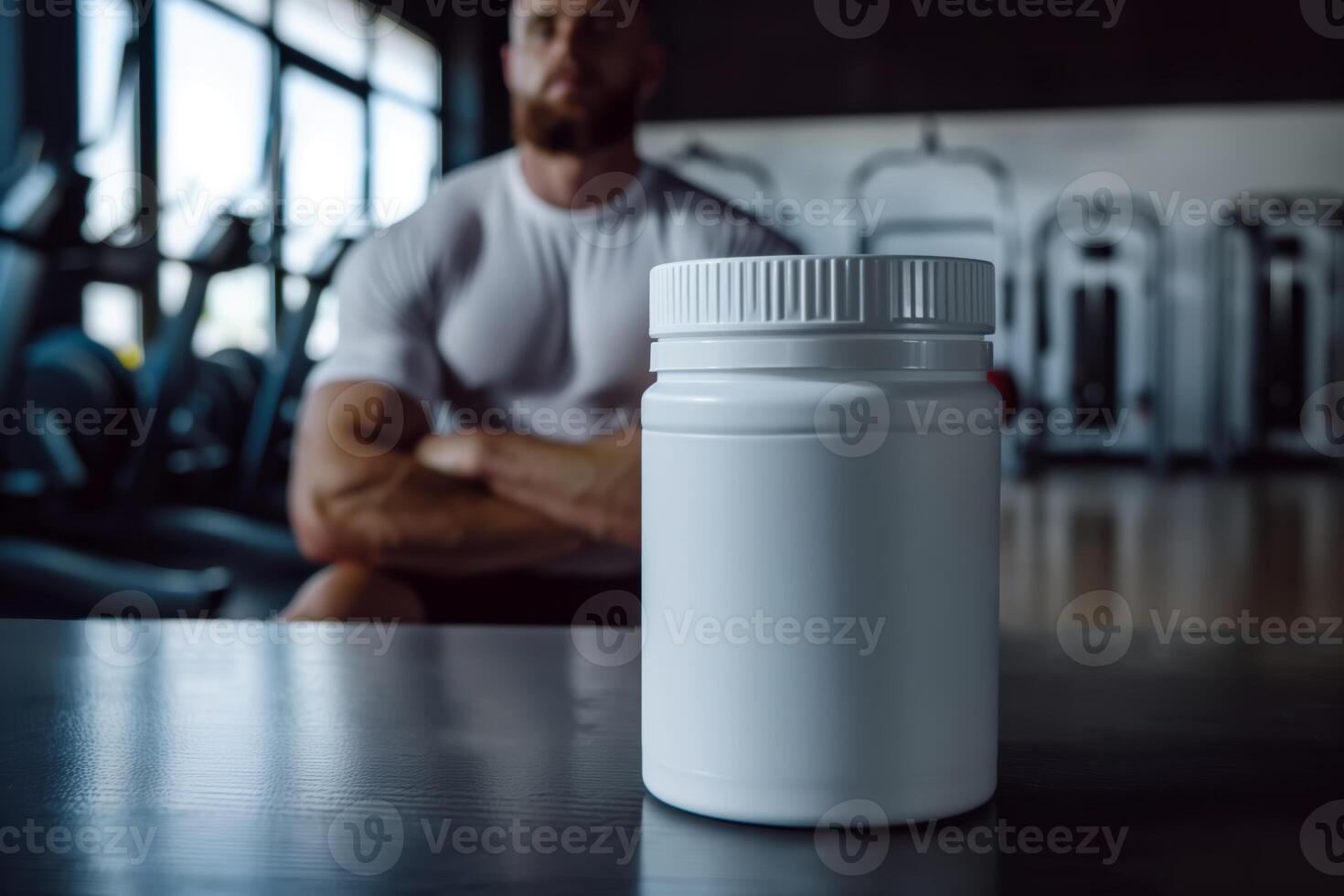 White supplement container on table in gym with athlete in background photo