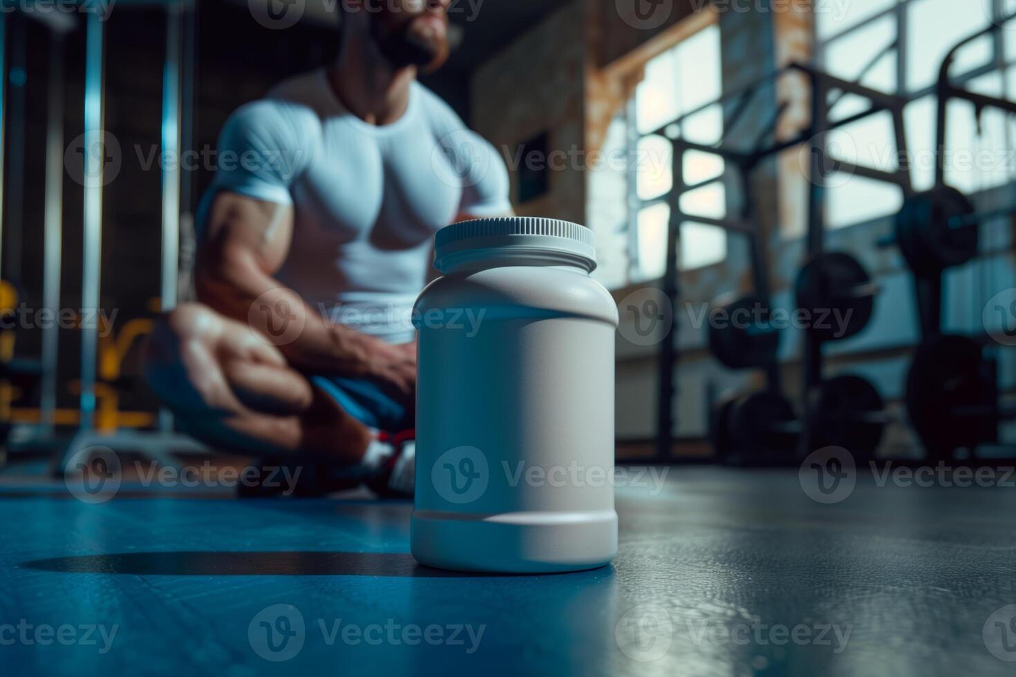 A close-up shot of a large, white plastic container with a screw-top lid. The container appears to be a sports nutrition supplement. It is in focus in the foreground photo