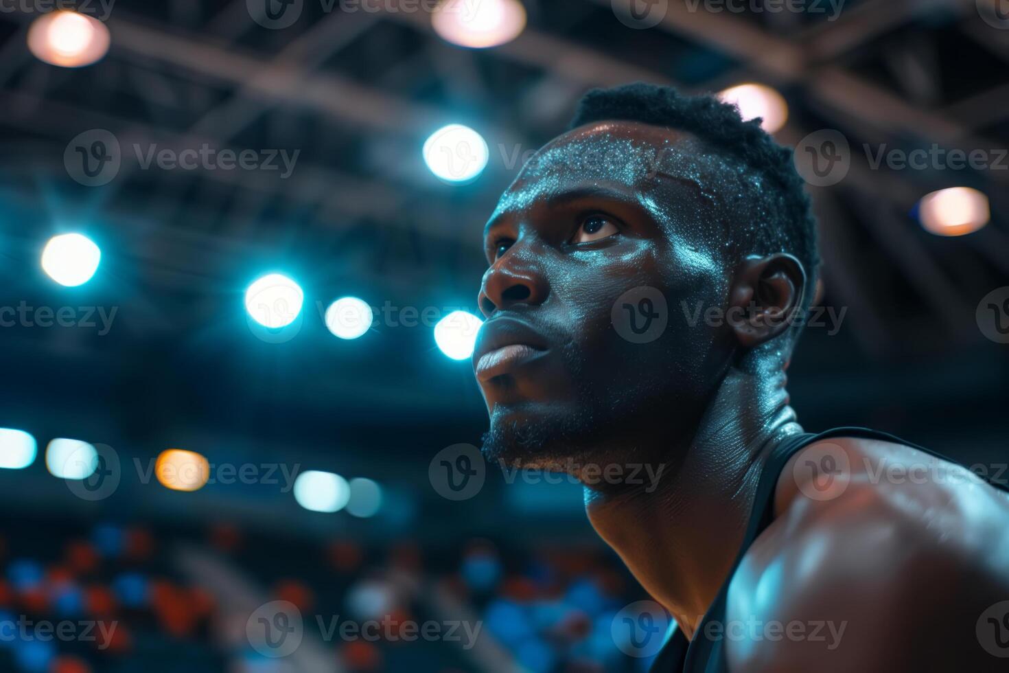 Basketball player looking up at stadium lights during game photo