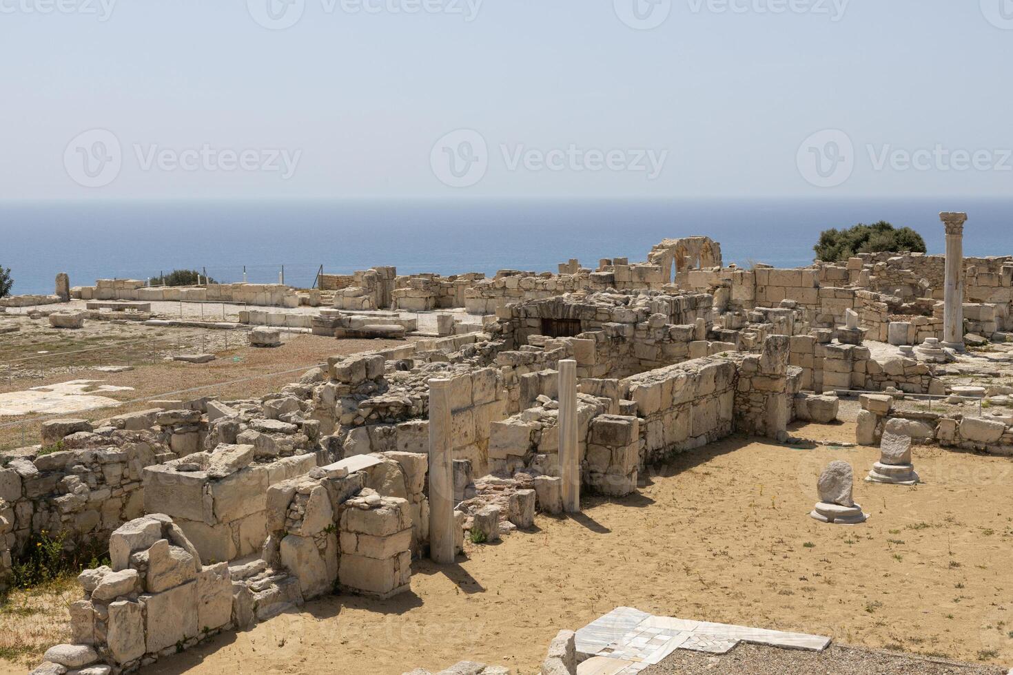 The extensive ruins of Kourion, with columns and remnants of ancient structures, set against the Mediterranean Sea. photo