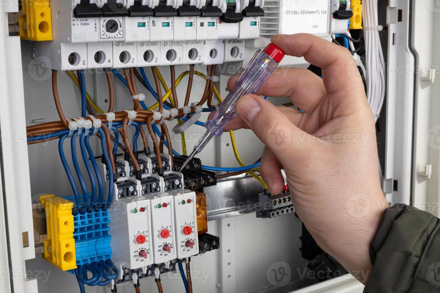 Technician Using Voltage Tester on Wiring photo
