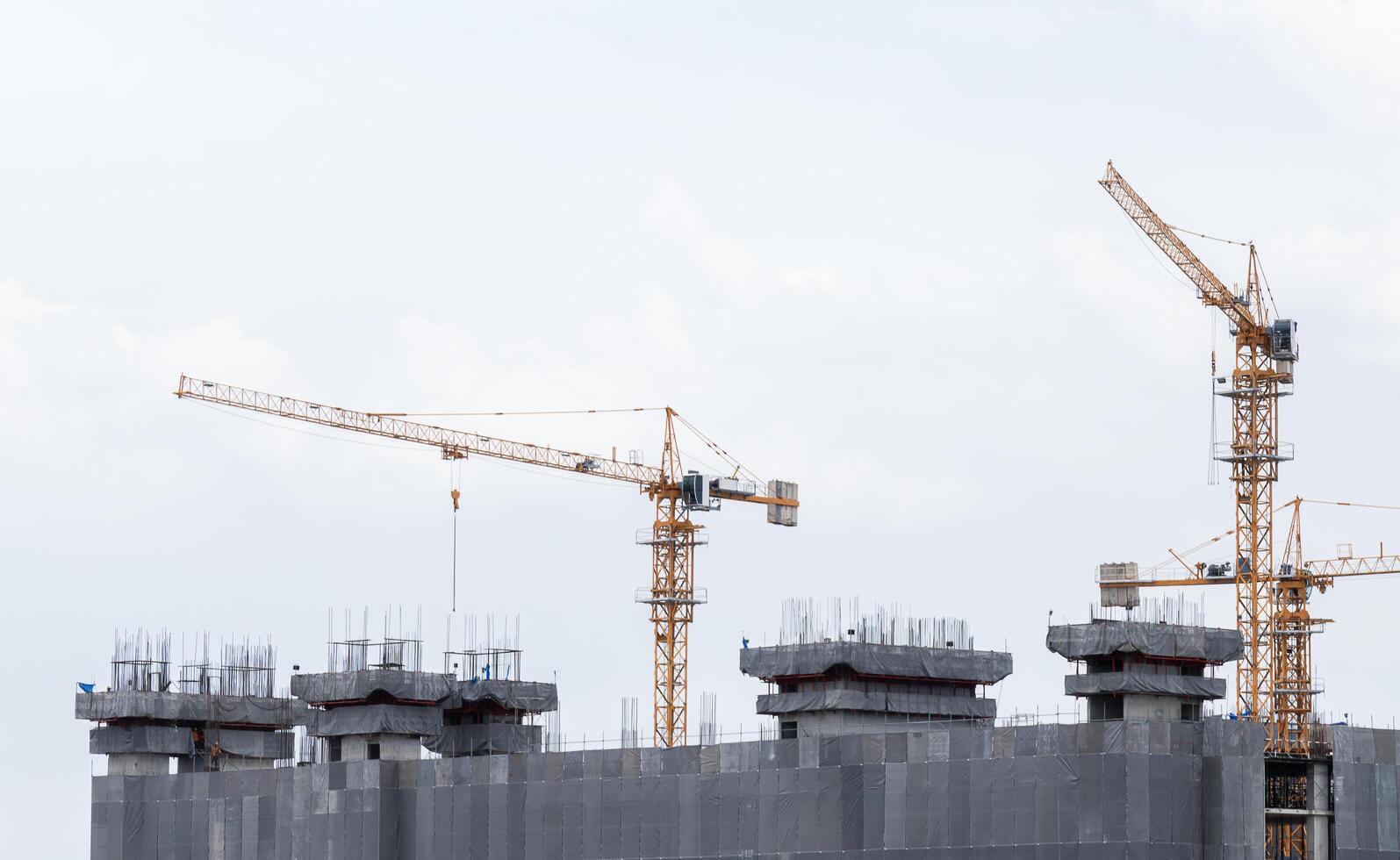 Tower construction crane in rooftop building construction site with blue sky background photo