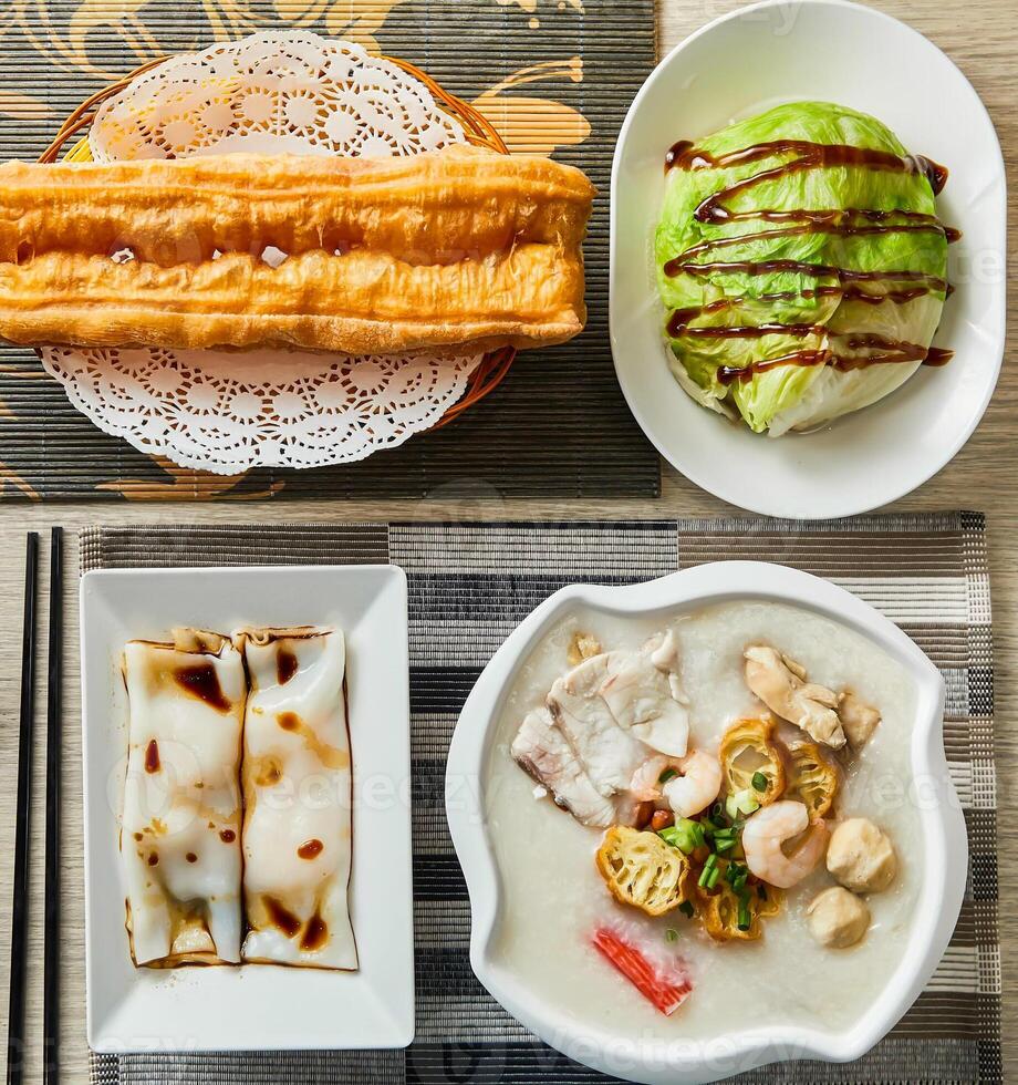 Fried dough sticks, stir fried cabbage, Barbecued pork rice roll, Boat Porridge, served in dish isolated on napkin top view of chinese food photo