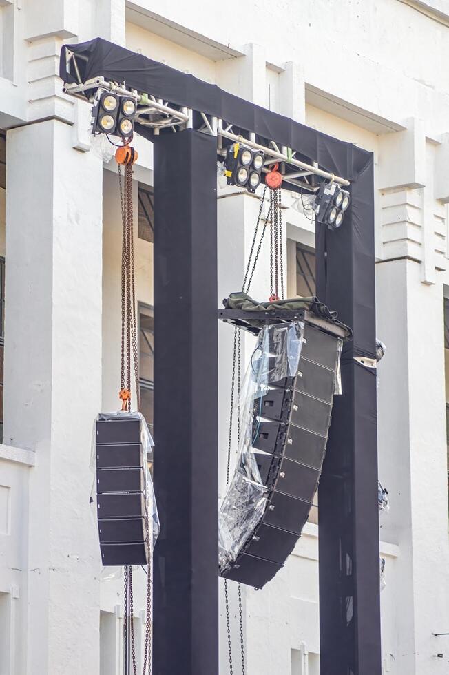 a pair of rigging, lighting, and line array speakers at a concert or large open-air performance photo