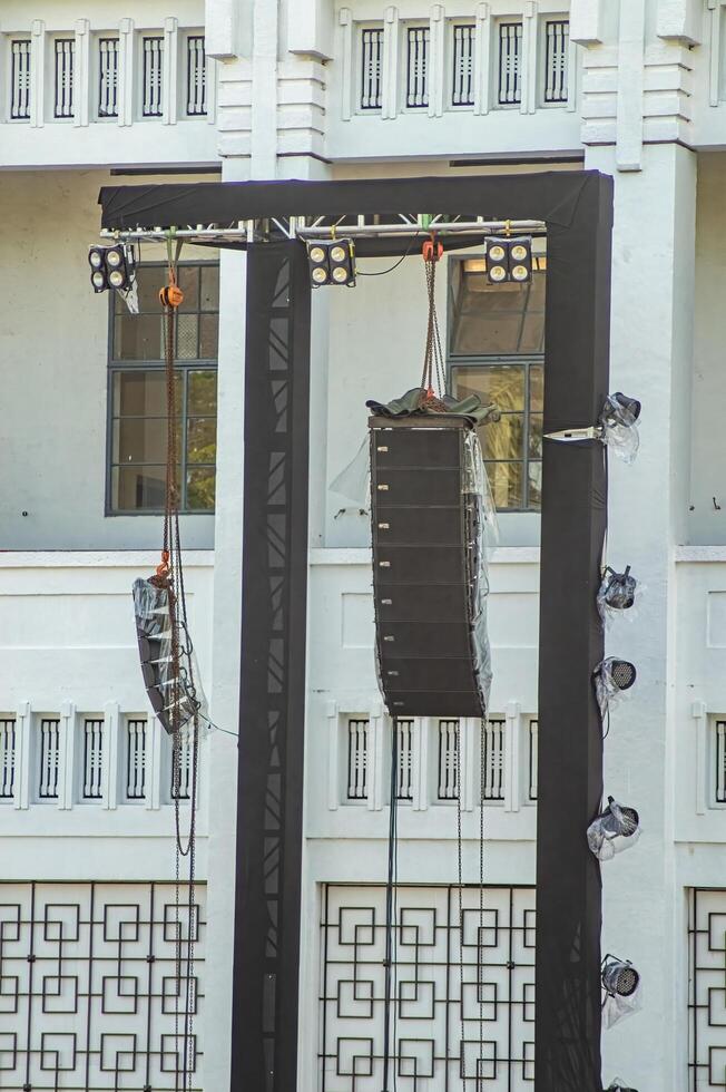 a pair of rigging, lighting, and line array speakers at a concert or large open-air performance photo