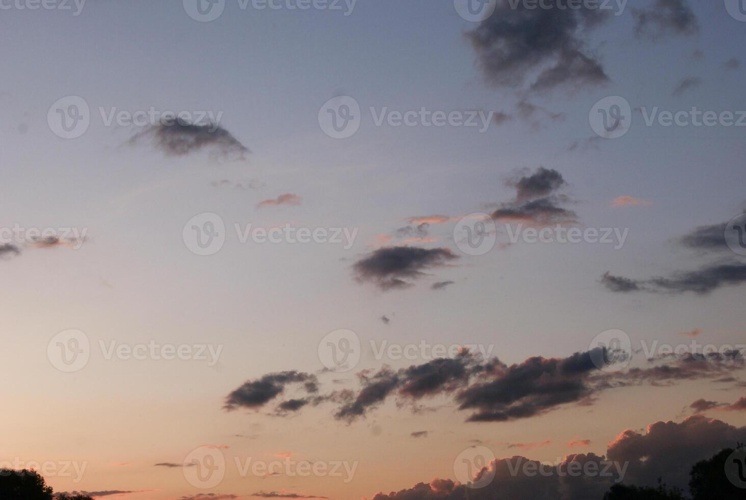 photo of a cloudy sky at sunset, with pink and orange hues.
