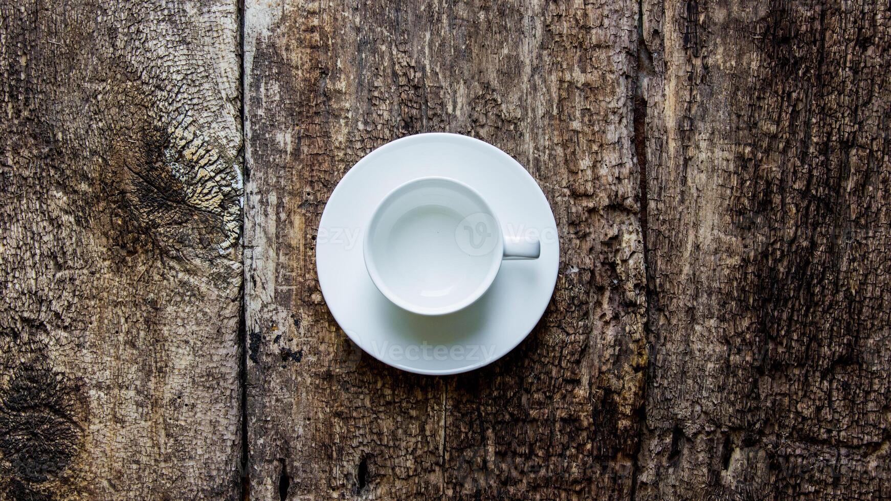 Coffee cup and saucer on old wooden table. Dark background. photo