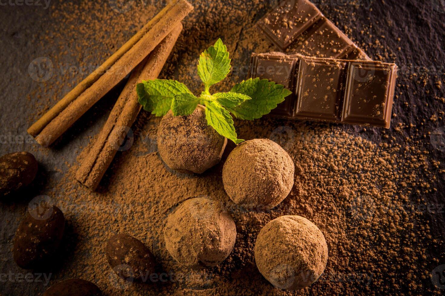 Chocolate truffle. Truffle chocolate candies with cocoa powder. Gourmet assorted truffles made by chocolatier.Chunks of chocolate and coffee beans photo