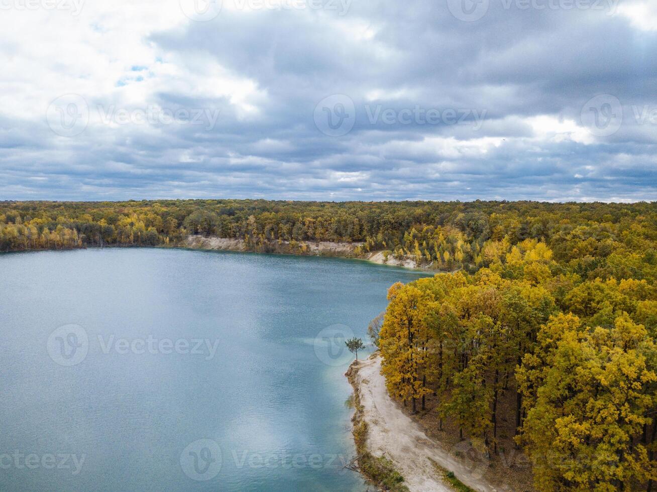 Aerial view of a beautiful autumn landscape with a river surrounded by forest, with a dramatic sky. photo
