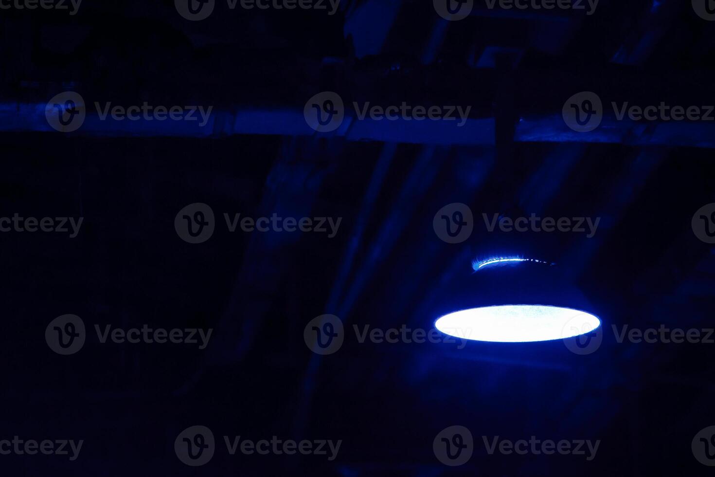 Old hanging lamp in the factory at night. Industrial night scene. Attic. Interior style with space for text. photo