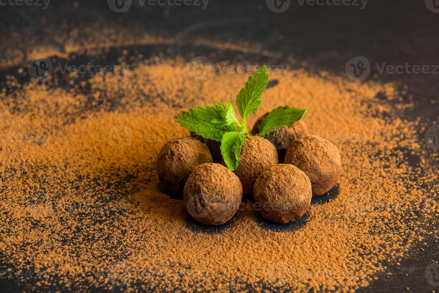 Chocolate truffle. Truffle chocolate candies with cocoa powder. Gourmet assorted truffles made by chocolatier.Chunks of chocolate and coffee beans photo
