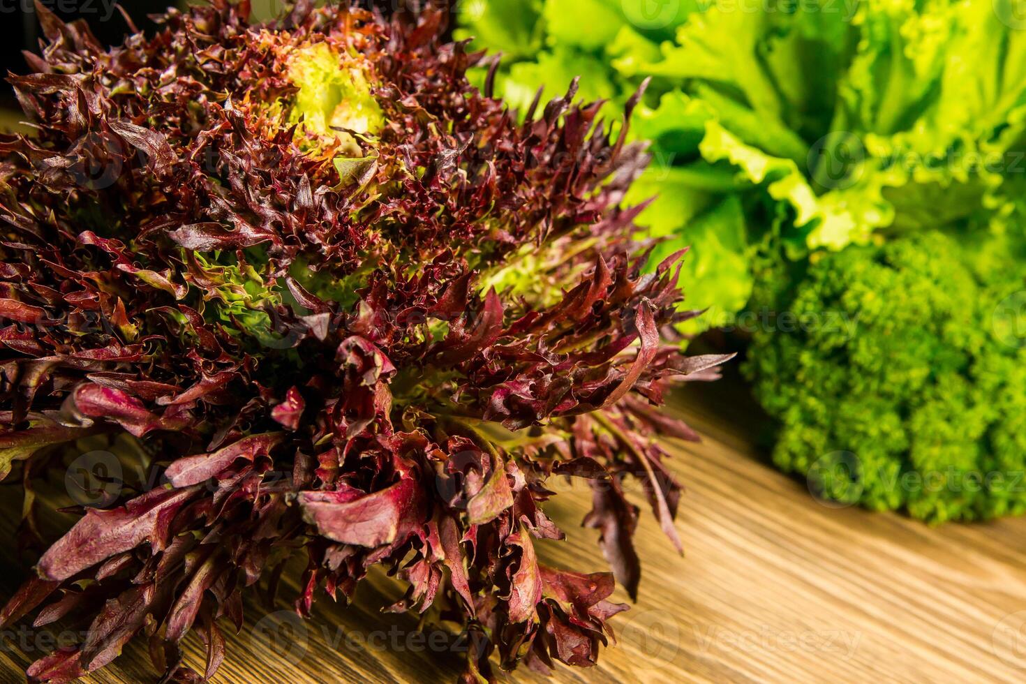 Leaves of lettuce and basil on a wooden background. Seasoning for the kitchen. Greenery. photo
