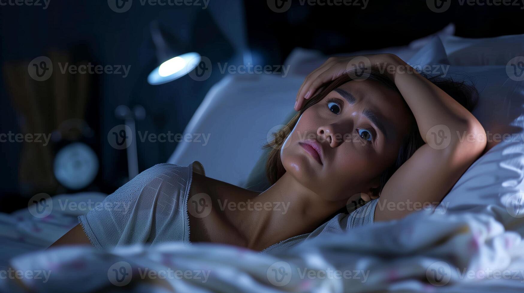 Insomniac Woman Lying Awake in Bed at Night, Looking Stressed Under Lamp Light, Battling Sleeplessness photo