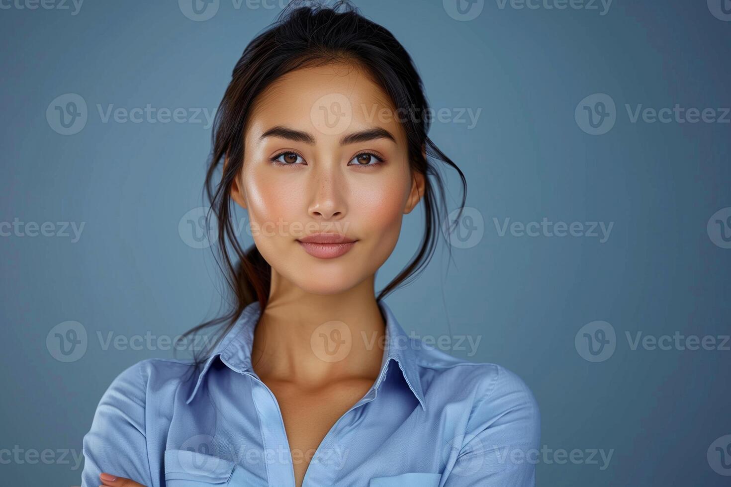 Professional Businesswoman Confident Expression Arms Crossed Blue Background Studio Portrait photo