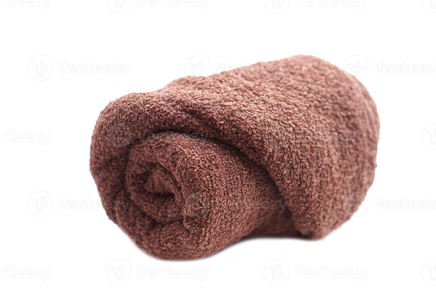 Rolled brown towel isolated on white background. Concept, clothes in daily life using. Towel for bathing, showering or spa massage. photo
