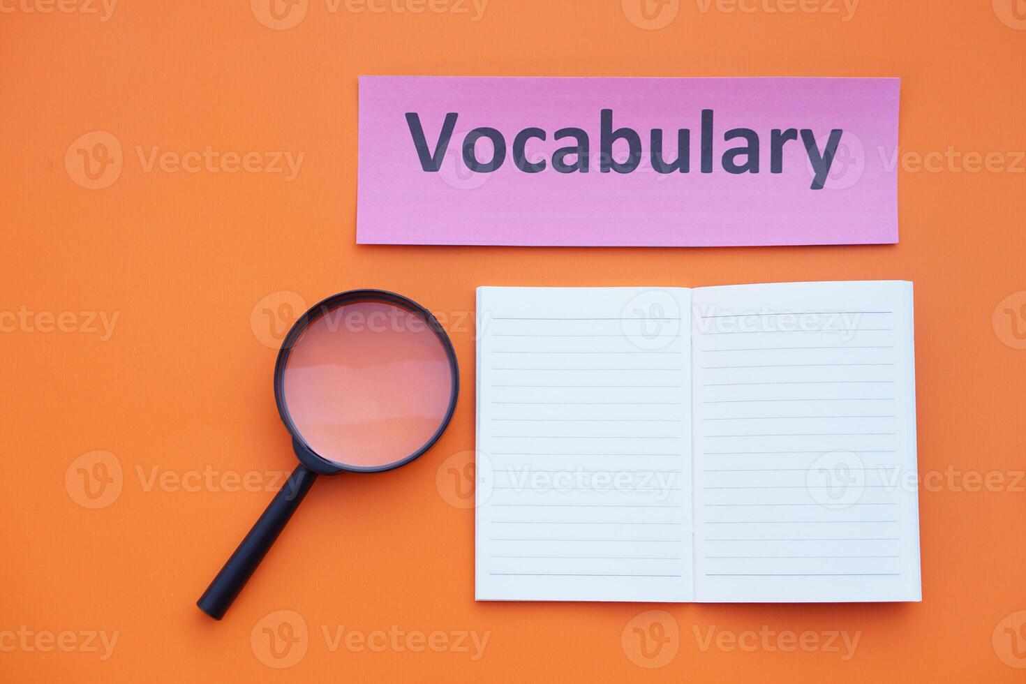 Magnifying glass, paper notebook and vocabulary card. Concept. Education material.Teaching aid. Learning language. Find or search vocabulay in lesson. photo