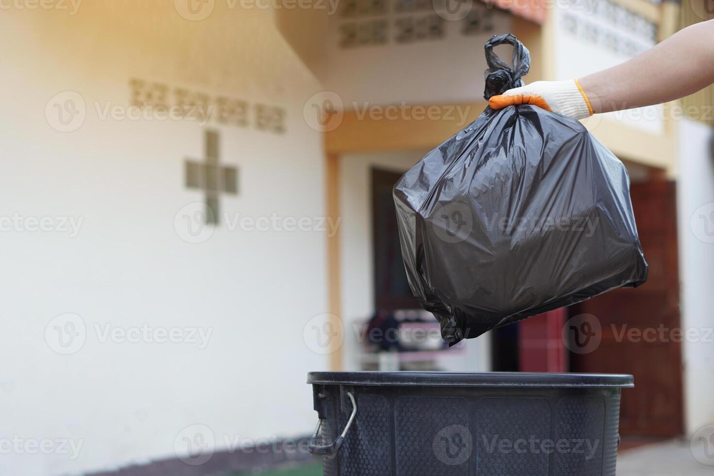 Hand holding garbage black bag putting in to the bin. Concept, garbage management, Keep clean for sanitary and community service for the best environment. Zero waste. photo