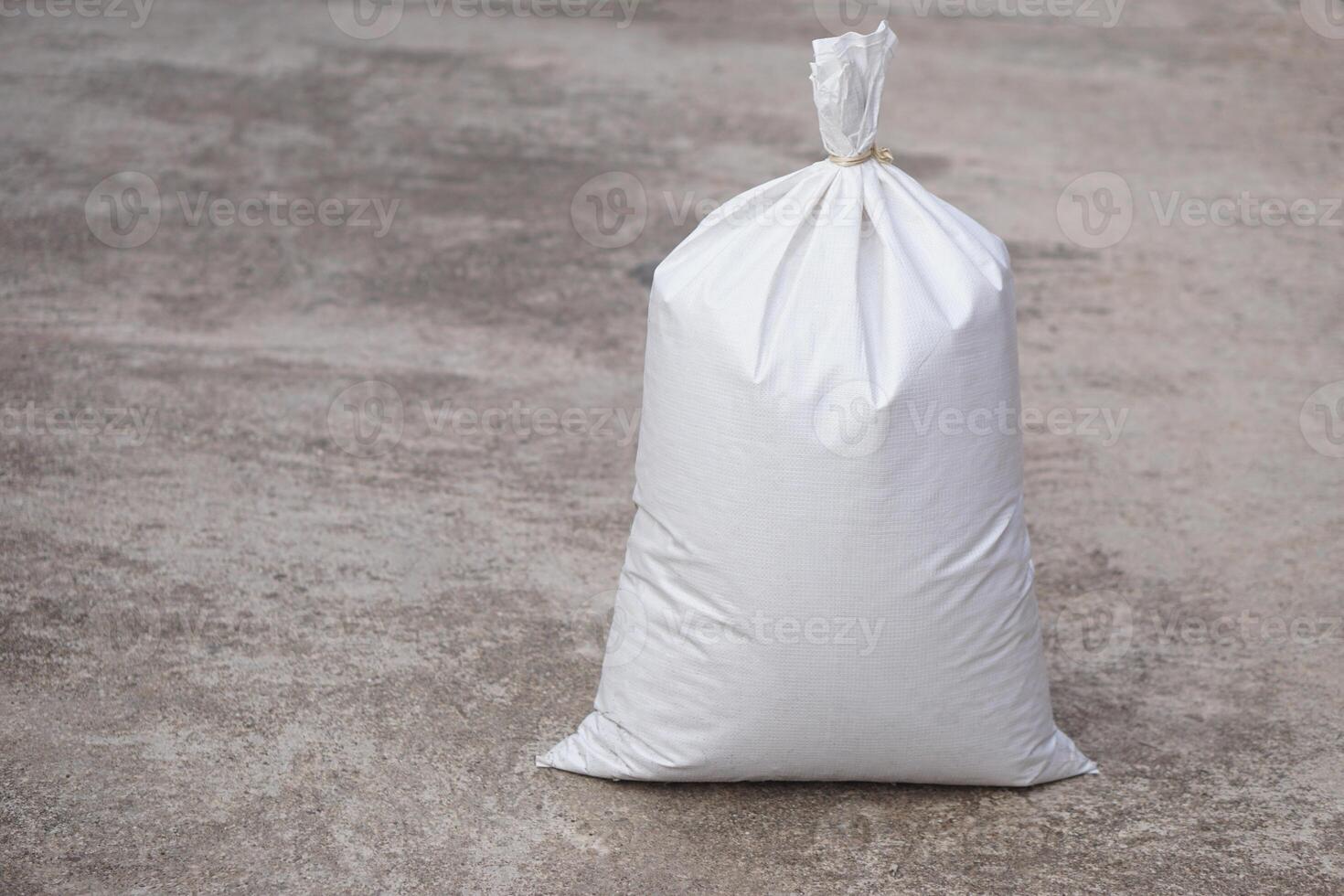 White polypropylene sack that contain full of agricultural grains, tied on the top with bamboo rope. Concept, reusable bag for contain crops, fertilizer or others. photo