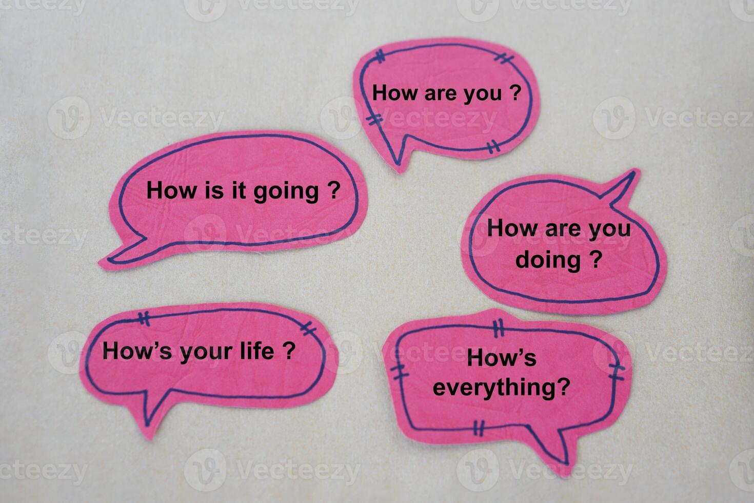 Pink paper speech bubbles cards with texts to ask questions about How are you Concept, Handmade English language teaching aid. English for communication in daily life. photo
