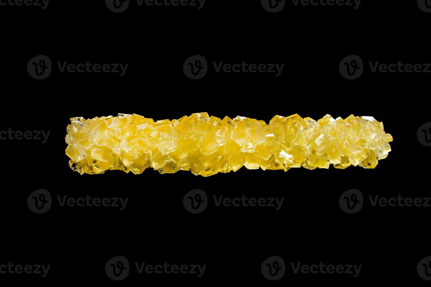 Crystallized sugar, bright yellow-orange crystals on a black background, refined product, with a place for an inscription photo