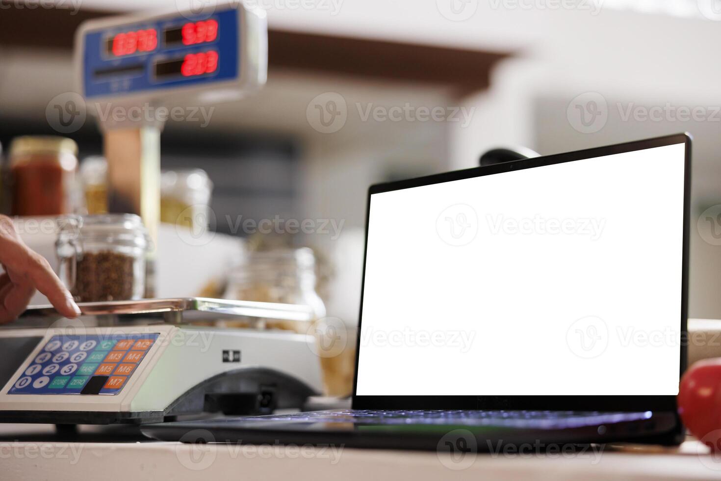 Close-up of laptop at cashier desk, showing isolated chromakey copyspace template. In local eco friendly market, digital laptop displaying blank white screen for advertising. photo