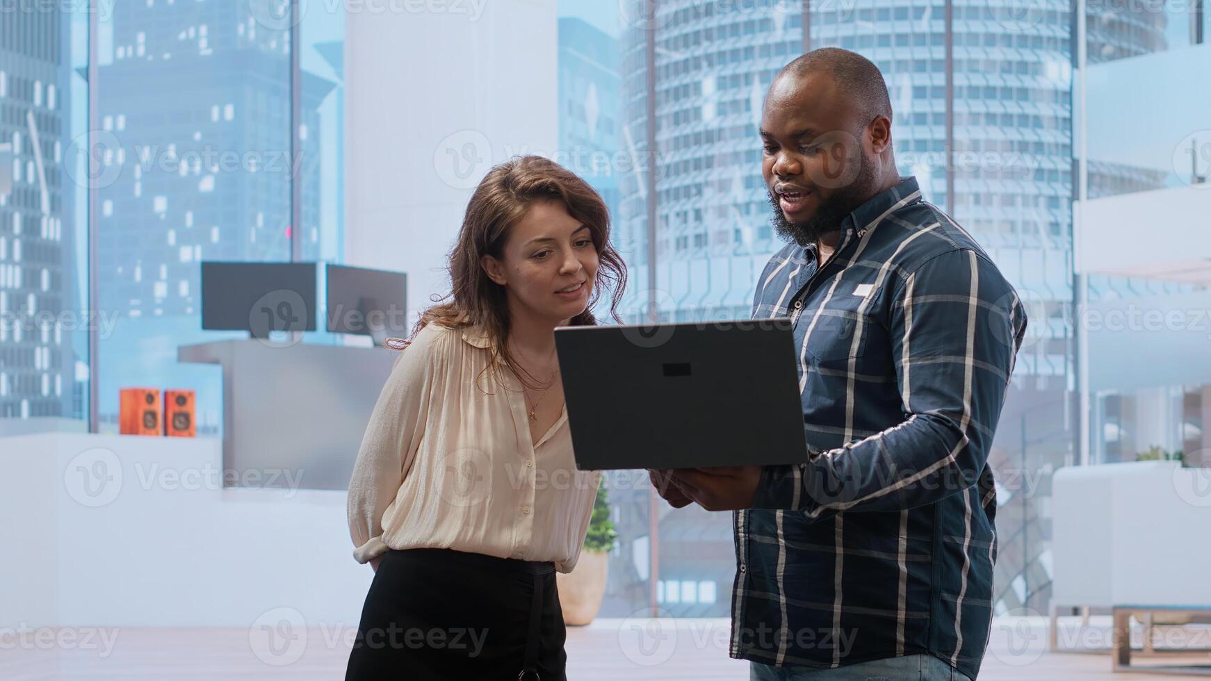 Realtor broker showing architectural blueprints on laptop to business team potential clients, presenting high class building space during tour. Offering insurance and legal assistance. Camera B. photo