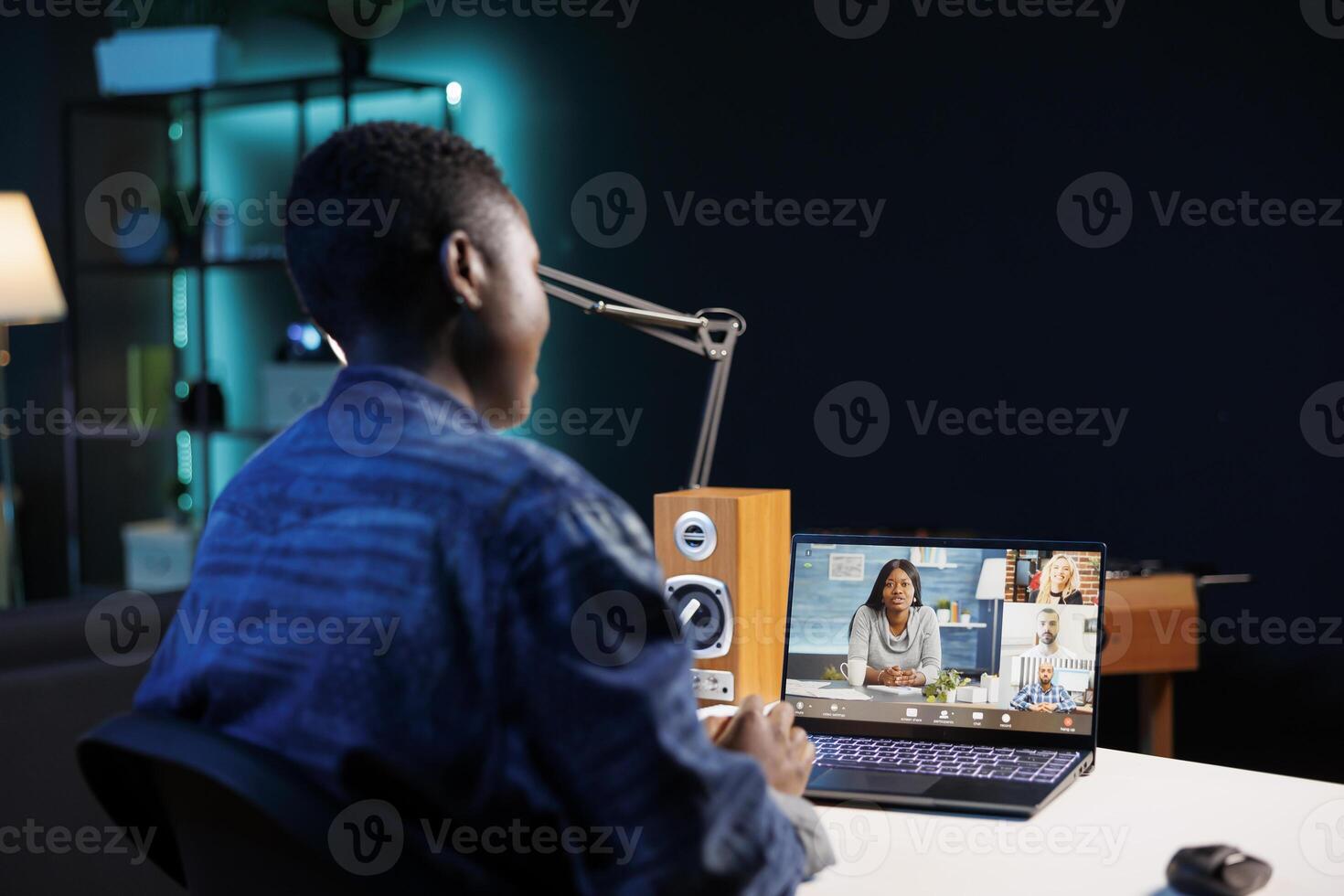 Black woman making call with group of colleagues on a digital laptop. Attending conference meetings and webinars via portable computer as an African American female freelancer. photo