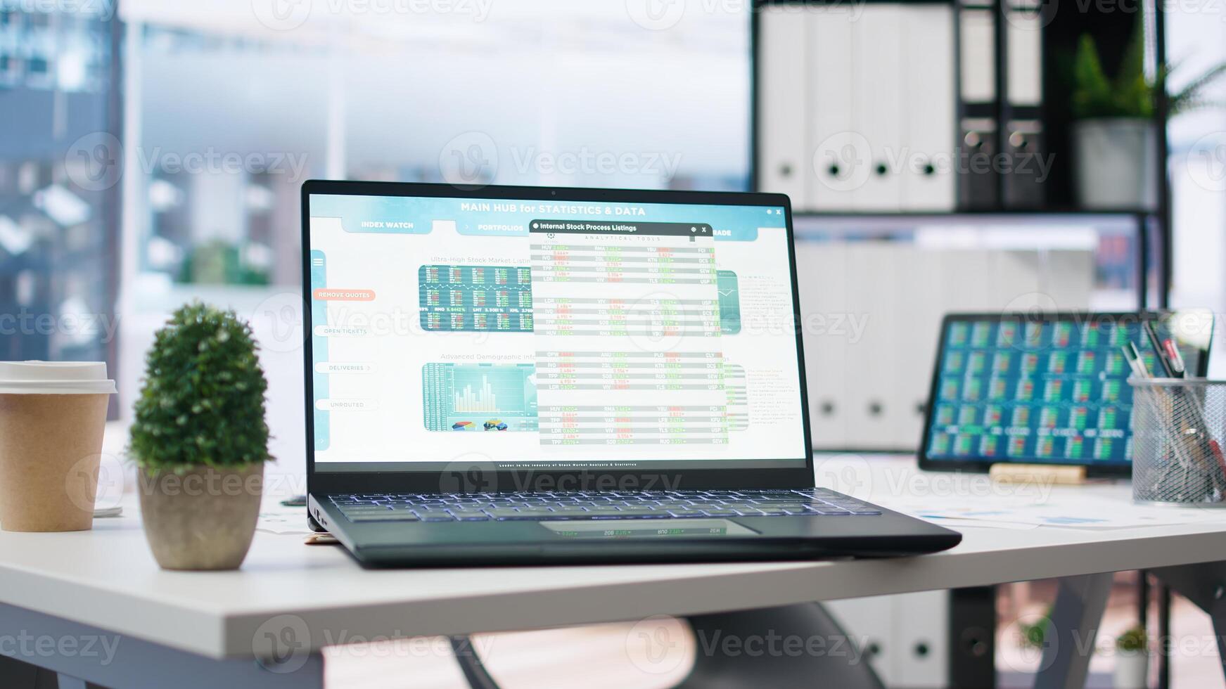 Empty office with stock portfolio on devices containing collection of investment bonds and other financial assets. Real time index indices showing stock demand surge on laptop and tablet photo