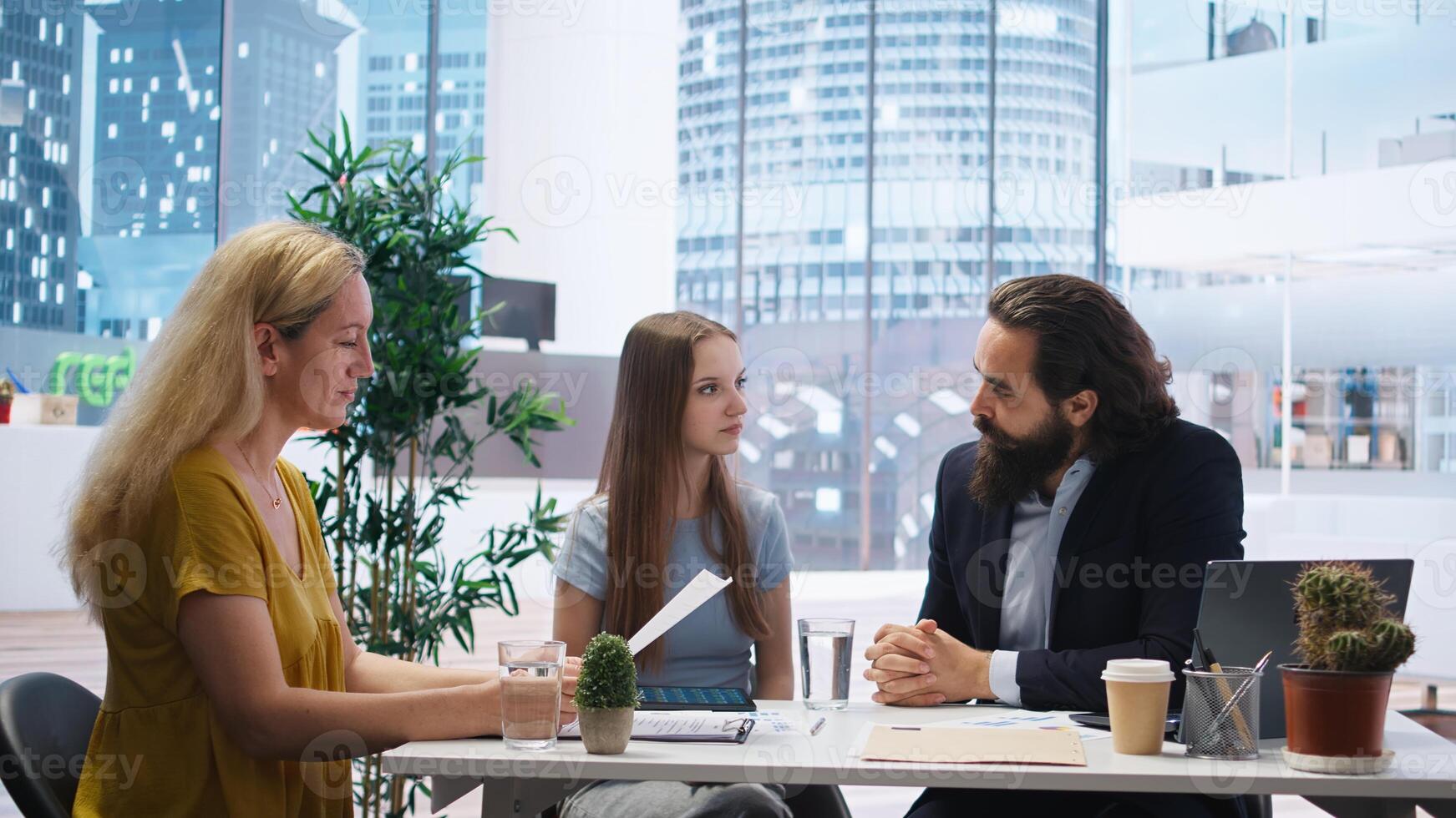Financial advisor assessing clients economic goals to provide personalized planning guide during office meeting. Agent optimizing investment returns for mother and daughter requesting help, camera A photo