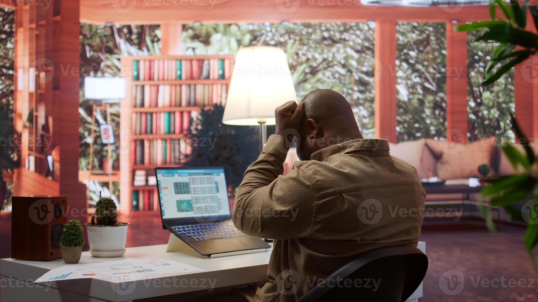 Business analyst calculating project funds and analytics at his home, allocating resources and solving tasks to accomplish objectives. Entrepreneur works on money management accounting. Camera B. photo