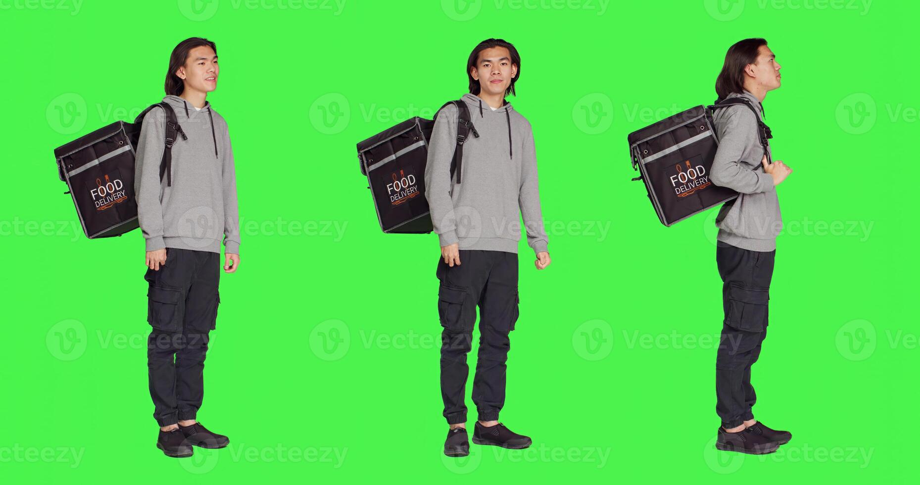 Young man works on food delivery with thermal backpack, standing over studio full body greenscreen. Asian person deliveryman carrying bag for takeout meal, to deliver orders to clients. photo