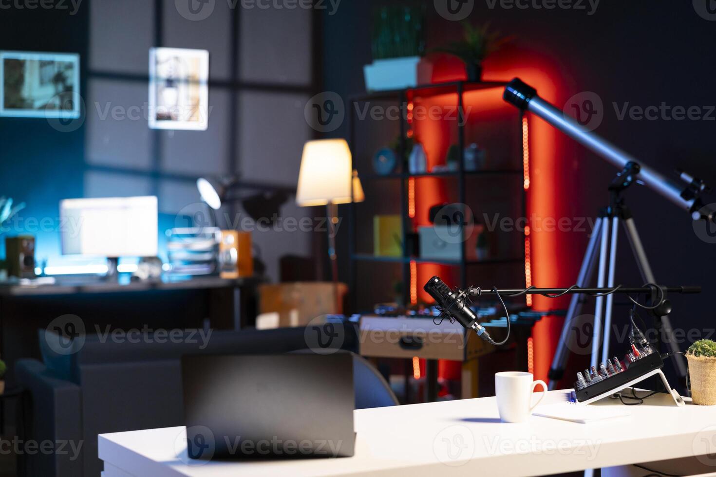 Internet production gear in empty home studio interior illuminated with RGB lights at night. Professional microphone, sound mixer and other content creation equipment in apartment room photo