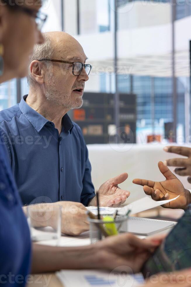 Mature couple meeting with a financial expert to develop a detailed retirement plan, focusing on savings, investments, and long term financial security. Discussing a pension option. photo