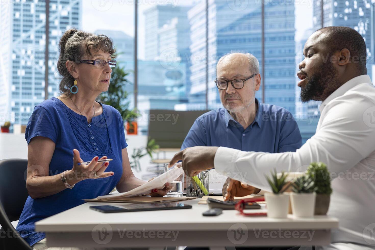 Senior citizens consulting a financial planner to explore various retirement options, ensuring their savings and investments are optimized for future stability. Exploring pension plans. photo