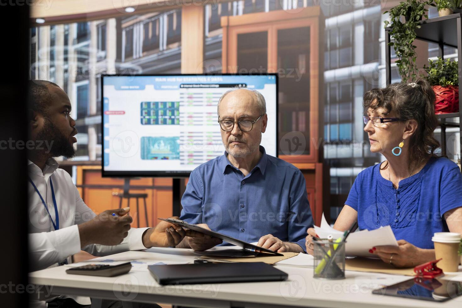 Elderly people exploring pension plans with a financial expert, focusing on long term financial stability and investment strategy. Clients consulting broker about their retirement options. photo