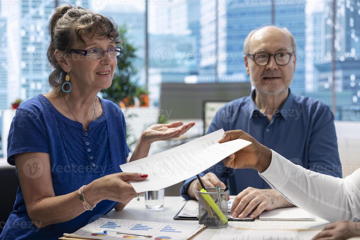 Financial advisor giving the retirement plan documents to old people, securing a contract with life insurance policy. Broker counseling clients to choose a suitable pension option. photo