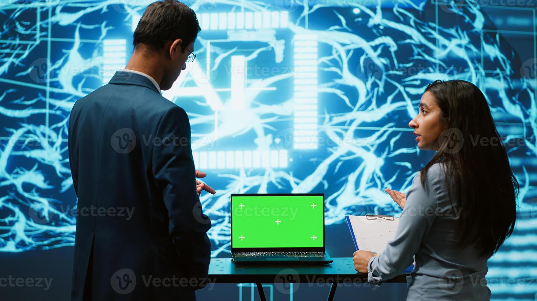 Startup coworkers looking over charts, using AI software on mockup laptop to take data driven decisions. Teamworking colleagues developing artificial intelligence solutions for company, camera A photo