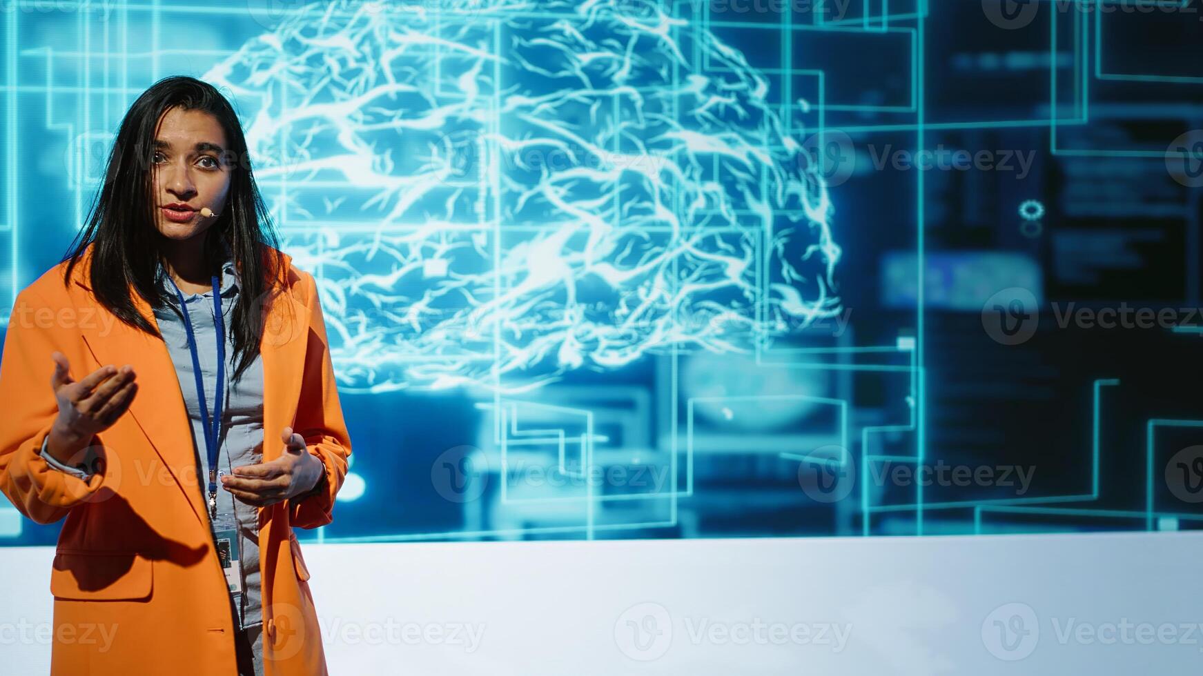 Tech company CEO using conference as platform to present latest AI services. Woman uses microphone to talk at convention with business investors interested in artificial intelligence, camera A photo