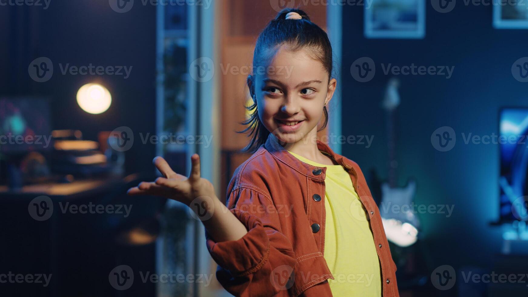 Cute smiling kid filming dance tutorial for other children watching her online social media content. Young cheerful influencer recording targeting generation Z users photo