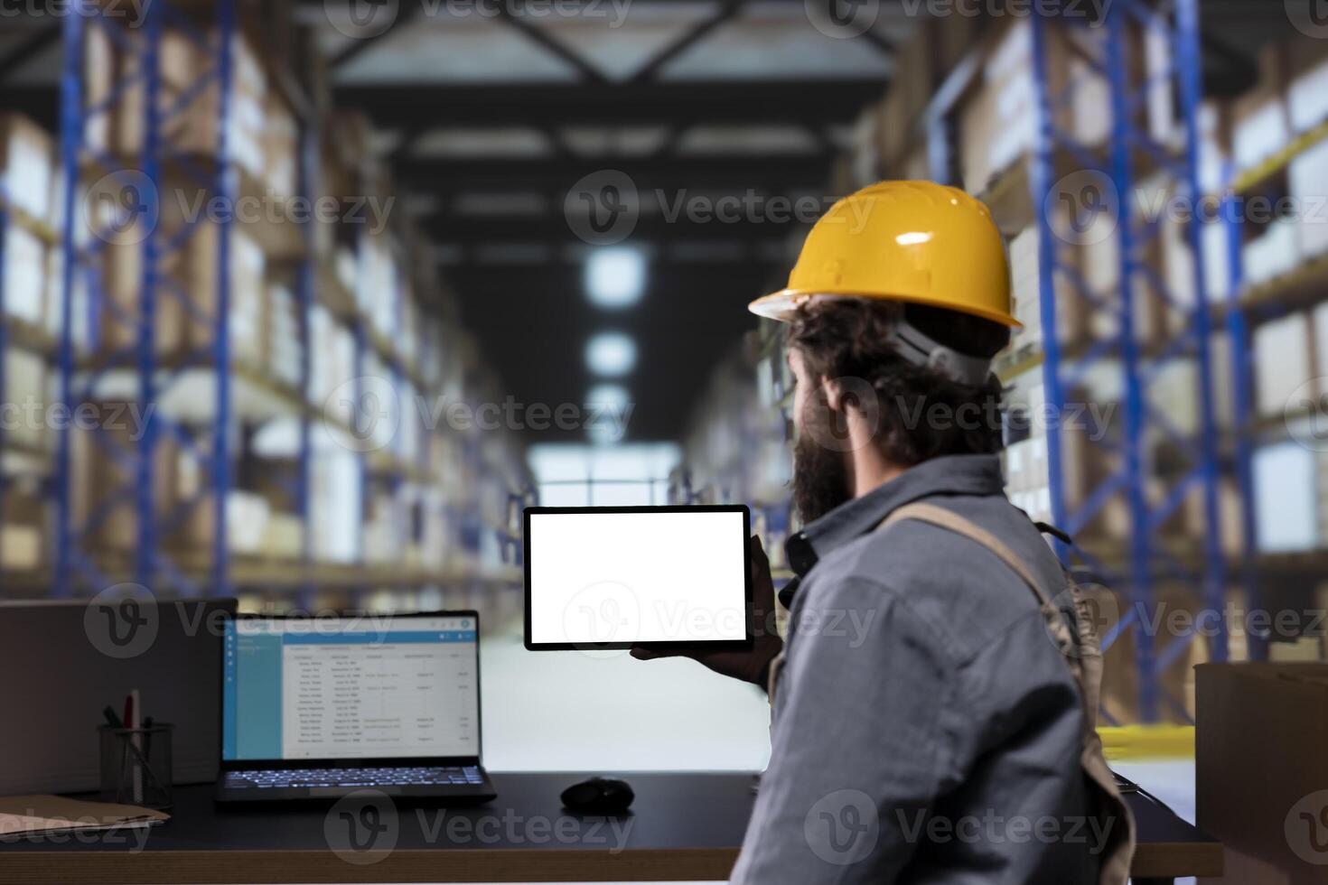 Stock manager looking at blank tablet display in storage room, reviewing list of cargo invoices for distribution. Engineer handling supply chain management and shipments, uses white screen. photo