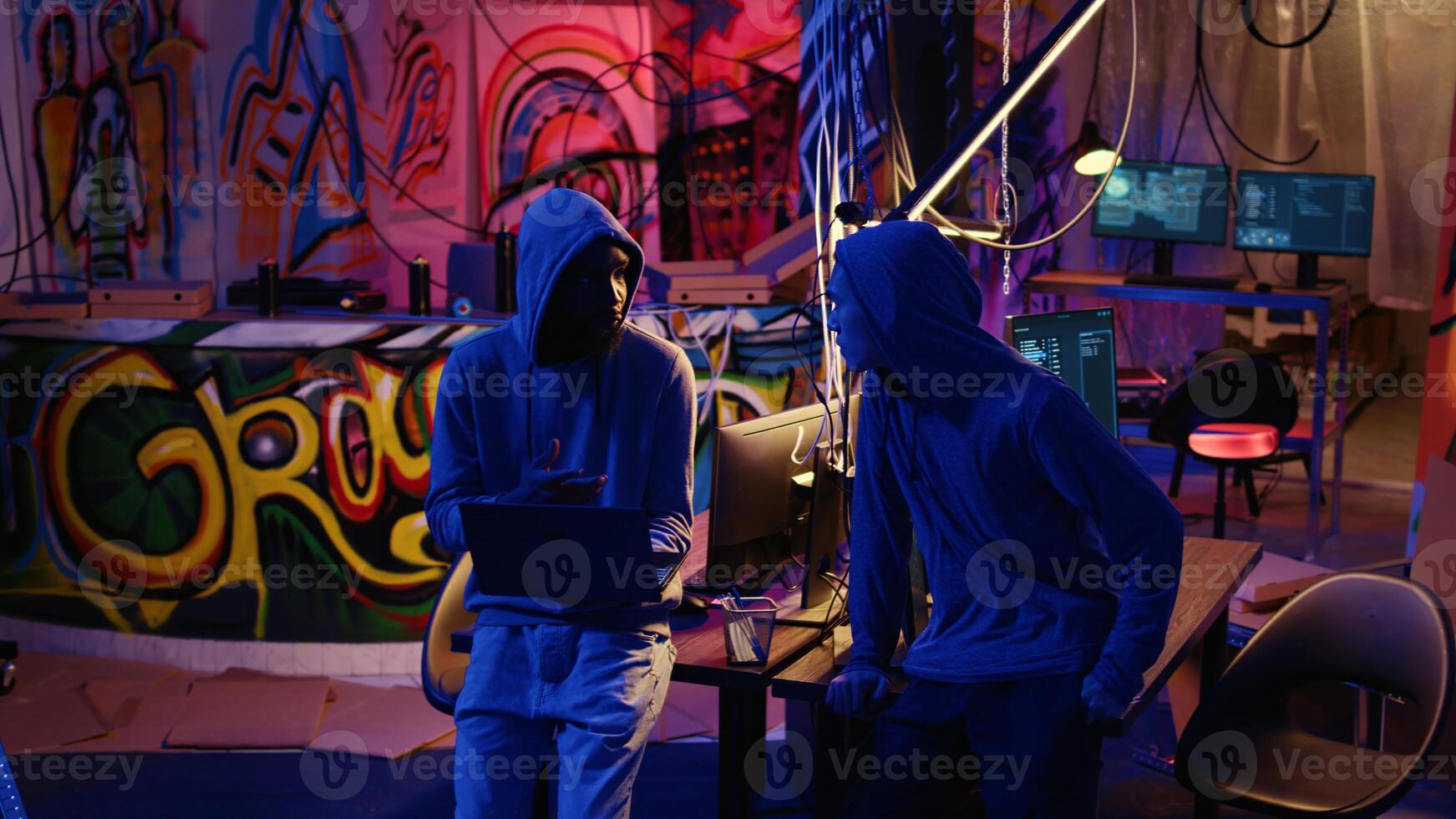 Trucking right shot of hackers brainstorming ways to find exploits for system vulnerabilities and use them to sell the fix to system owner. Malicious programmers using laptop to do hacking photo